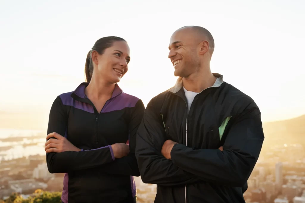 happy athletic couple smiling outdoors at sunset utc ()