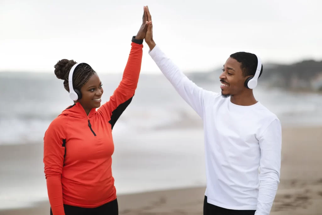 smiling man and woman giving high five on beach utc